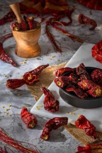 Kashmiri red chillies with mini wooden pestle and mortar