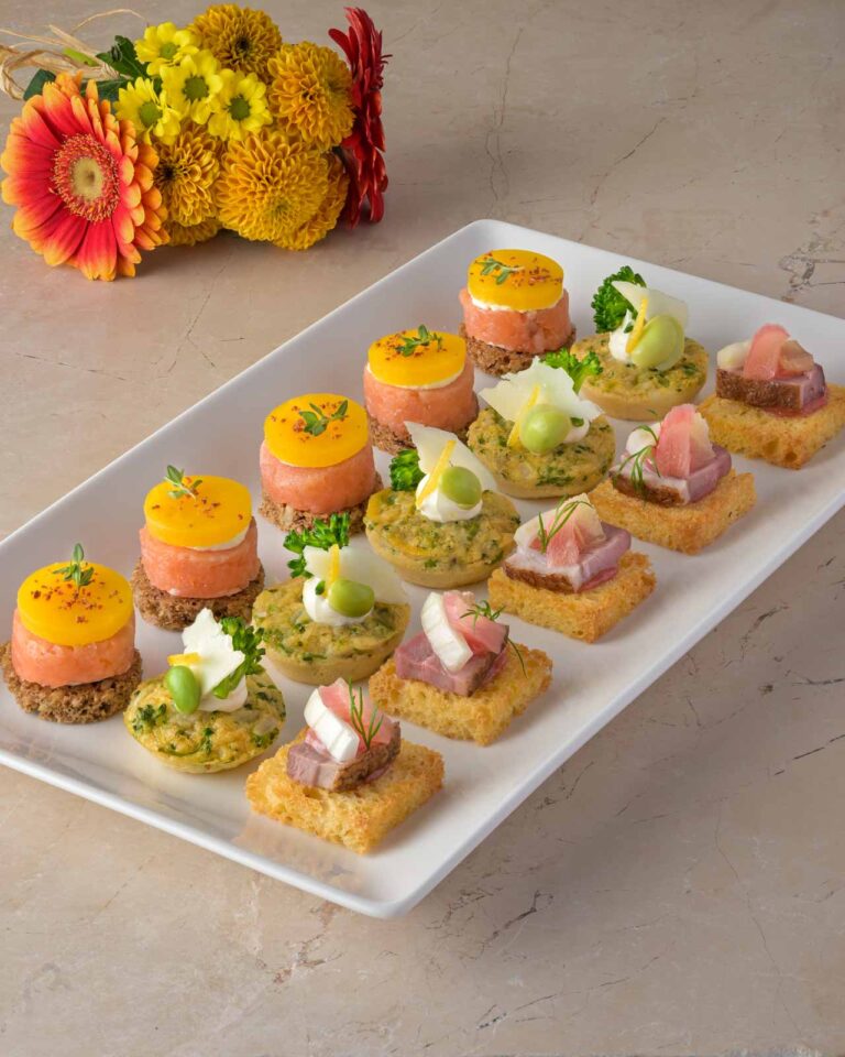 CanapÃ© platter with mini quiche, rye bread and duck bites